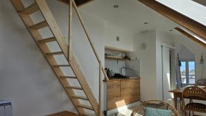 a wooden staircase in a room with a kitchen at Studio cosy au bord de mer in Lancieux