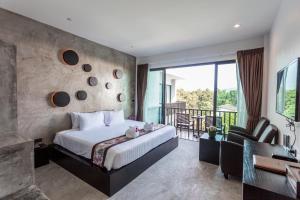 a hotel room with a bed and a balcony at Aonang Viva Resort - SHA Plus in Ao Nang Beach +37 photos