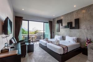 a hotel room with a large bed and a balcony at Aonang Viva Resort - SHA Plus in Ao Nang Beach