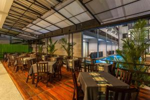 a dining room with tables and chairs and plants at Aonang Viva Resort - SHA Plus in Ao Nang Beach