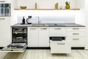 a kitchen with white cabinets and a dishwasher at Appartamento San Carlo in Tirano