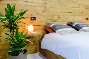 - une chambre avec un lit et une plante en pot dans l'établissement Appartamento San Carlo, à Tirano