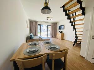 a dining room and living room with a table and chairs at Storey holiday cottages, Jaros awiec in Jarosławiec