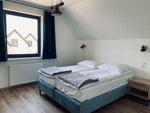 a large bed in a room with a window at Storey holiday cottages, Jaros awiec in Jarosławiec