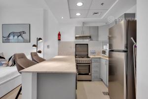 uma cozinha com um frigorífico de aço inoxidável e um balcão em Sleek Studio - Red Residence-L8 - Near ISD Stadium em Dubai