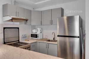 cocina con armarios blancos y nevera de acero inoxidable en Sleek Studio - Red Residence-L8 - Near ISD Stadium en Dubái
