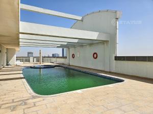 a swimming pool on top of a building at Sleek Studio - Red Residence-L8 - Near ISD Stadium in Dubai