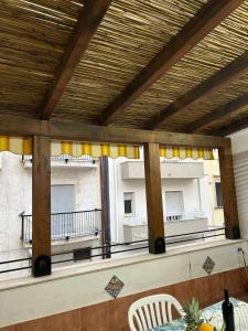 uma varanda com cortinas amarelas e uma mesa e cadeiras em Casa Vita in centro em Balestrate