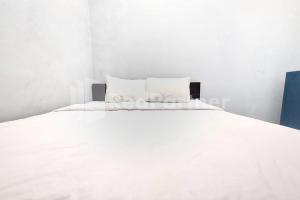 a large white bed with white sheets and pillows at Vins Homestay Kroya Mitra RedDoorz in Cilacap