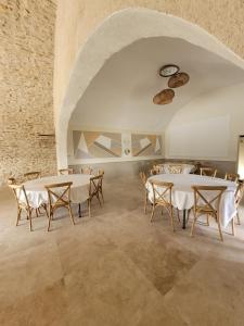 Les Grandes Mollières في Peyruis: غرفة طعام مع طاولات وكراسي بيضاء