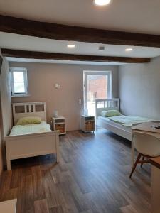 2 Betten in einem Zimmer mit Holzböden in der Unterkunft Ferienhof Klemme in Rinteln