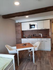 a kitchen with white cabinets and a table and chairs at Ferienhof Klemme in Rinteln