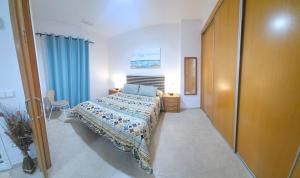 a bedroom with a bed and a blue curtain at Apartamento con piscina y cerca de la playa in Canet de Berenguer