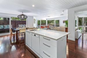 an open kitchen and living room with a table and chairs at Dual-living amongst the rainforest, Little Cove in Noosa Heads