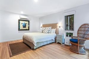 ein Schlafzimmer mit einem Bett, einem Stuhl und einem Fenster in der Unterkunft Dual-living amongst the rainforest, Little Cove in Noosa Heads