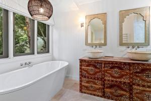 ein Bad mit einer Badewanne, 2 Waschbecken und Fenstern in der Unterkunft Dual-living amongst the rainforest, Little Cove in Noosa Heads