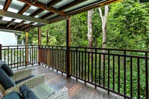 eine abgeschirmte Veranda mit zwei Sofas auf einer Terrasse in der Unterkunft Dual-living amongst the rainforest, Little Cove in Noosa Heads