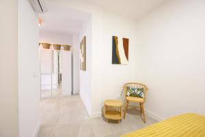 1 dormitorio con silla y pared blanca en Luxury oceanfront 3 bedrooms & 2 bath by 10ToSea, en Fuengirola