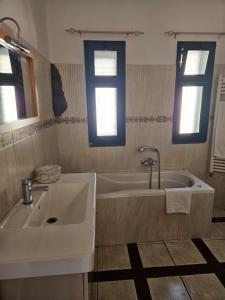 La salle de bains est pourvue d'une baignoire, d'un lavabo et de 2 fenêtres. dans l'établissement Villa Courrier, à Tremestieri Etneo