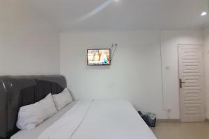una camera con un letto e una foto appesa al muro di SPOT ON 93782 Hasibuan Homestay Syariah a Medan