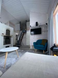 a living room with a blue chair and a table at Käpälämäki puhtaan veden äärellä omassa rauhassa in Enonkoski
