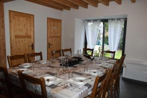 une salle à manger avec une table, des assiettes et des verres à vin dans l'établissement Gîte de montagne Le Batoua, à Sailhan