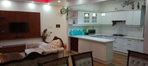 uma cozinha com armários brancos e uma mesa e cadeiras em Royal Nest (AS) 3 BHK Suite em Pune