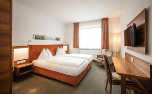 Cette chambre comprend un lit et un bureau. dans l'établissement Hotel Clara, à Bressanone