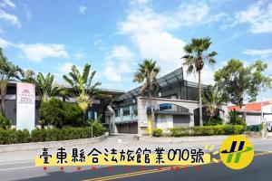 台东正一商务汽车旅馆 中华路一馆的街道前有棕榈树的建筑