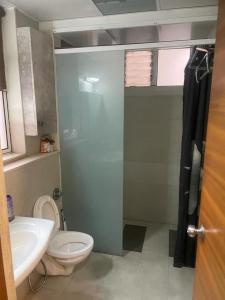 uma casa de banho com um WC, um lavatório e um chuveiro em Royal Nest (AS) 3 BHK Suite em Pune