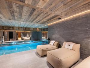 a living room with a swimming pool and two chairs at Chalet Marcel - Chalets pour 12 Personnes 691 in Saint-Marcel
