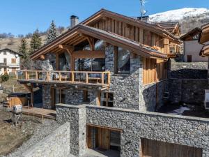 a house with a stone facade with a balcony at Chalet Marcel - Chalets pour 12 Personnes 691 in Saint-Marcel