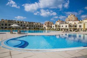 a large swimming pool in front of a building at Cozy Villa with Pool Access in Ras al Khaimah