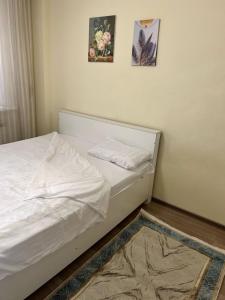 un letto in una camera da letto con due immagini sul muro di Квартира a Astana