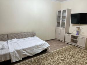 una camera con letto, TV e armadio di Квартира a Astana
