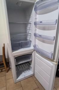 an empty refrigerator with its door open in a kitchen at Apartmány Pražská in Ústí nad Labem