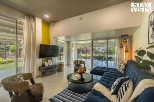 a living room with a blue couch and a tv at StayVista's Silver Grove - Serene Haven with Expansive Lawn & Terrace in Nashik