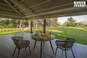 een tafel met eten en drinken op een patio bij StayVista's Silver Grove - Serene Haven with Expansive Lawn & Terrace in Nashik