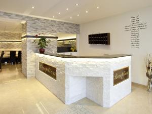 a bar in a lobby with a stone wall at Central City Hotel in Füssen