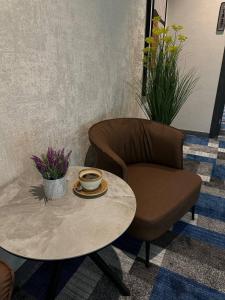 uma mesa de centro e uma cadeira com uma chávena de café em HL 212 em Tashkent