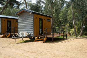 a small cabin with a porch and stairs to it at Bright Cabin Park in Bright