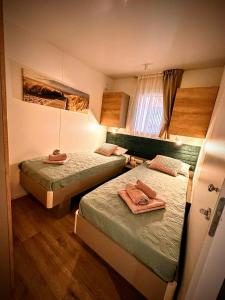 um pequeno quarto com 2 camas e uma janela em Mobile home TASHA em Biograd na Moru