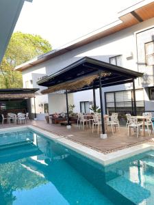 a patio with tables and chairs next to a pool at Acacia Garden Inn in Coron