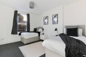 biała sypialnia z 2 łóżkami i oknem w obiekcie Perfect Retreat 4bed House Trent Bridge & Forest w Nottingham