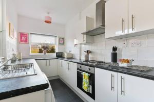 a white kitchen with white cabinets and a sink at Perfect Retreat 4bed House Trent Bridge & Forest in Nottingham