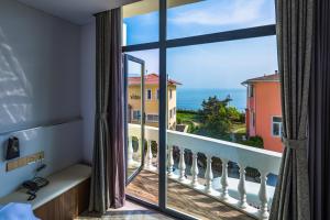 a room with a view of the ocean from a balcony at Qingdao Villa Inn in Qingdao