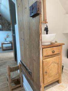 的住宿－La folie douce, maison d'hôtes，一间带木制橱柜和水槽的浴室