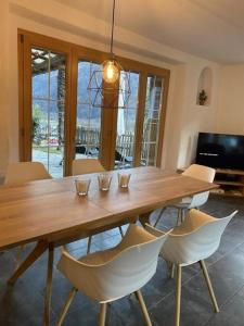uma sala de jantar com uma mesa de madeira e cadeiras em Top - Rustico mit Aussenwhirlpool beheizt und Sauna em Dongio