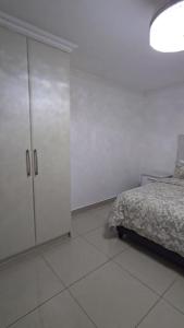 1 dormitorio blanco con 1 cama y armario en Durban Muslim Accomdation HALAAL SELF CATERING NO ALCOHOL 2 to 4 SLEEPER, 3 Adults only or 2 Adults plus 2 Small Kids en Durban