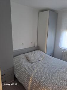 a small bedroom with a bed and a cabinet at Dulce hogar in Miengo